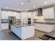 Modern kitchen featuring white cabinets, a large island, granite counters, and stainless steel appliances at 4132 Woods Rider Loop, Odessa, FL 33556