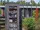 Charming community 'Little Free Library' filled with books surrounded by colorful plants at 4132 Woods Rider Loop, Odessa, FL 33556
