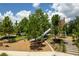View of a modern playground featuring a slide and play structures on a mulch surface at 4132 Woods Rider Loop, Odessa, FL 33556