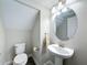 Neat powder room featuring a pedestal sink, round mirror, and modern fixtures at 4132 Woods Rider Loop, Odessa, FL 33556