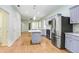 Open kitchen with stainless steel appliances, gray cabinetry, marble countertops, and hardwood-style floors at 4512 Paper Mulberry Pl, Riverview, FL 33578