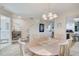 Cozy dining area features a round table, chandelier, and easy access to the kitchen and powder room at 620 Garland Cir, Indian Rocks Beach, FL 33785