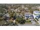 Aerial view of luxury modern home with a manicured lawn and three-car driveway in a tree-lined neighborhood at 6223 Bayshore Blvd, Tampa, FL 33611