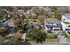 Aerial view of luxury modern home with a manicured lawn and three-car driveway in a tree-lined neighborhood at 6223 Bayshore Blvd, Tampa, FL 33611