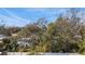Landscaped backyard view with a wooden fence, mature trees, and lush greenery under a blue sky at 6223 Bayshore Blvd, Tampa, FL 33611