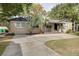 Charming single-story home with a well-manicured lawn, concrete driveway, and decorative palm trees at 6223 Bayshore Blvd, Tampa, FL 33611