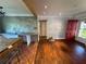 Bright living room featuring hardwood floors, neutral walls, and a red entry door at 6223 Bayshore Blvd, Tampa, FL 33611