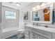Well-lit bathroom featuring a tub-shower combo, gray vanity, modern fixtures, and decorative coastal accents at 6291 Sebring St, Weeki Wachee, FL 34607