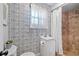Bathroom with decorative blue wallpaper, white vanity, and shower with updated tile at 6291 Sebring St, Weeki Wachee, FL 34607