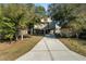 Exterior view of the home showing landscaping and large driveway at 6291 Sebring St, Weeki Wachee, FL 34607