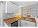 Functional kitchenette with light cabinets, accent backsplash, and updated countertops at 6291 Sebring St, Weeki Wachee, FL 34607