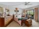 Cozy bedroom with carpet, ceiling fan, a large window overlooking a balcony, and wood furniture at 6303 23Rd N St, St Petersburg, FL 33702