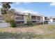 Exterior view of townhomes featuring outdoor patios, green space, mature landscaping, and fenced yard at 6303 23Rd N St, St Petersburg, FL 33702