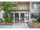 Townhouse exterior featuring two front doors with screens and decorative stone walkway and tropical landscaping at 6303 23Rd N St, St Petersburg, FL 33702