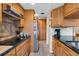 Galley kitchen with black countertops, stainless steel refrigerator, tiled floors and ample cabinet space at 6303 23Rd N St, St Petersburg, FL 33702