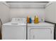 Laundry room features a white washer and dryer set with storage space for cleaning supplies at 6303 23Rd N St, St Petersburg, FL 33702