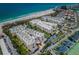 Expansive aerial view of the beachfront condominium complex with lush landscaping, parking, and beach access at 6500 Sunset Way # 202, St Pete Beach, FL 33706