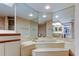 Bathroom featuring a marble-surround tub, mirrored walls, and vanity at 6500 Sunset Way # 202, St Pete Beach, FL 33706