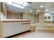 Bathroom featuring a marble-surround tub, mirrored walls, and vanity at 6500 Sunset Way # 202, St Pete Beach, FL 33706