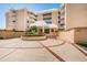 Inviting entrance to the beachfront condominium with well-maintained landscaping and a circular driveway at 6500 Sunset Way # 202, St Pete Beach, FL 33706