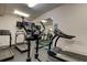 Community gym featuring treadmill, elliptical machine, television and large mirrors at 6500 Sunset Way # 202, St Pete Beach, FL 33706