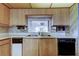 Kitchen sink and appliances are built into light wood cabinets and countertops at 6500 Sunset Way # 202, St Pete Beach, FL 33706