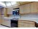 Kitchen features light wood cabinets, countertops, tile backsplash, and appliances at 6500 Sunset Way # 202, St Pete Beach, FL 33706