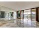 Spacious living room with mirrored wall, sliding glass doors, and a view of the lush tropical balcony at 6500 Sunset Way # 202, St Pete Beach, FL 33706