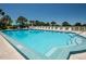 Community pool with lounge chairs and umbrellas, providing a relaxing oasis for residents at 6500 Sunset Way # 202, St Pete Beach, FL 33706