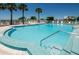 Community pool with lounge chairs and umbrellas, perfect for enjoying sunny days at 6500 Sunset Way # 202, St Pete Beach, FL 33706