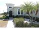 Charming front entrance featuring lush landscaping, stone accents and a private walkway at 920 Regal Manor Way, Sun City Center, FL 33573