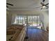 Spacious living room featuring hardwood floors, a fan, and sliding glass doors to the outdoors at 920 Regal Manor Way, Sun City Center, FL 33573