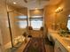 Bright bathroom featuring a glass shower, double sink vanity, and a window seat at 9350 Gulfstream, Englewood, FL 34224