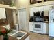 Bright kitchen featuring white appliances and cabinets with warm countertops at 9350 Gulfstream, Englewood, FL 34224