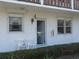 Inviting condo showcasing a well-lit entryway, white exterior, and neat landscaping at 1 Quails Run Blvd # 2, Englewood, FL 34223