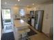 Well-equipped kitchen featuring stainless steel appliances, a central island, and ample white cabinetry at 1 Quails Run Blvd # 2, Englewood, FL 34223