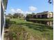 This tranquil pondside view features lush, grassy expanses and several multi-story residential buildings at 1 Quails Run Blvd # 2, Englewood, FL 34223