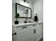 Bathroom with white vanity, decorative mirror, and sleek black fixtures at 10118 66Th Ave, Seminole, FL 33772