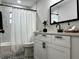 Bathroom with white vanity, decorative mirror, and marble-look tile in shower at 10118 66Th Ave, Seminole, FL 33772
