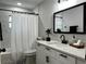 Bathroom with white vanity, decorative mirror, and marble-look tile in shower at 10118 66Th Ave, Seminole, FL 33772
