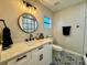 Charming bathroom featuring black fixtures, patterned tile floor, and a decorative mirror at 10118 66Th Ave, Seminole, FL 33772