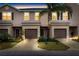 Inviting exterior view of townhomes, showcasing dark shutters and a lush, landscaped lawn at sunset at 1034 Grantham Dr, Sarasota, FL 34234