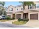 Inviting exterior view of townhomes, showcasing dark shutters and a lush, landscaped lawn on a cloudy day at 1034 Grantham Dr, Sarasota, FL 34234