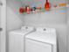 Functional laundry room with a washer, dryer, and overhead shelving, ideal for keeping laundry organized at 1034 Grantham Dr, Sarasota, FL 34234