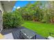 A backyard deck with outdoor seating offers a relaxing space with a view of a green lawn and mature foliage at 1118 S Moody Ave, Tampa, FL 33629