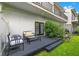 A backyard deck with cushioned seating offers a relaxing outdoor space with a view of the lawn and foliage at 1118 S Moody Ave, Tampa, FL 33629