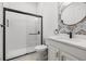 Contemporary bathroom with black framed shower, and elegant round mirror at 1118 S Moody Ave, Tampa, FL 33629