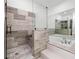 Modern bathroom showcasing glass enclosed shower and soaking tub with neutral tile at 1118 S Moody Ave, Tampa, FL 33629