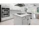 Bright white kitchen with stainless steel double oven, island and modern appliances at 1118 S Moody Ave, Tampa, FL 33629
