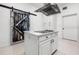Bright kitchen featuring a white island, modern range hood, and rustic barn door at 1118 S Moody Ave, Tampa, FL 33629